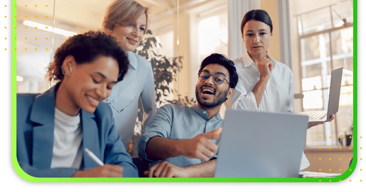 A group of office workers checking something out in a computer