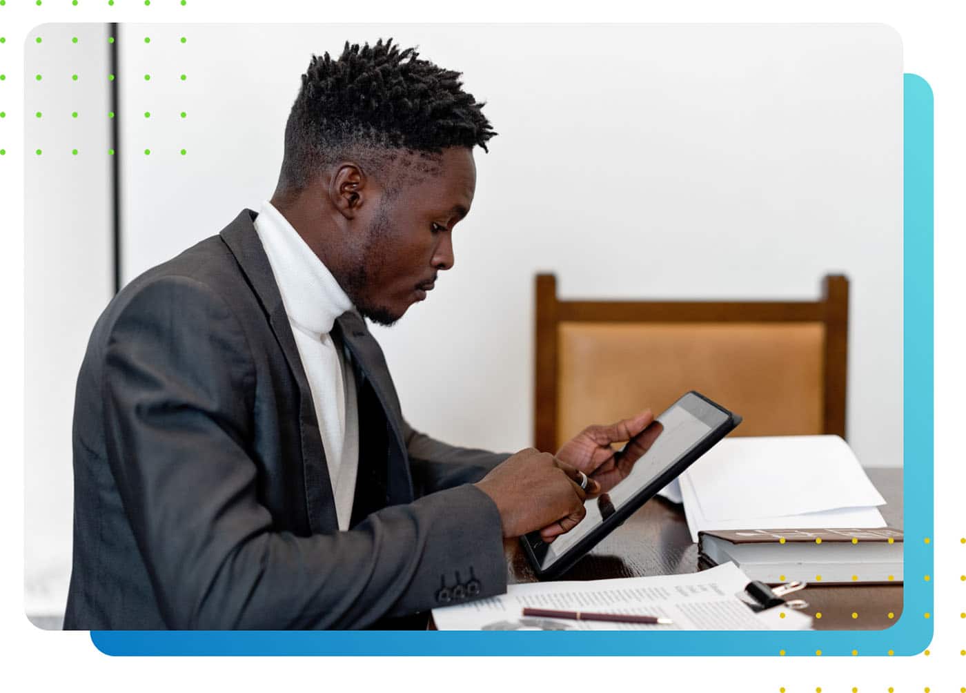 A man working on his iPad with documents on his table