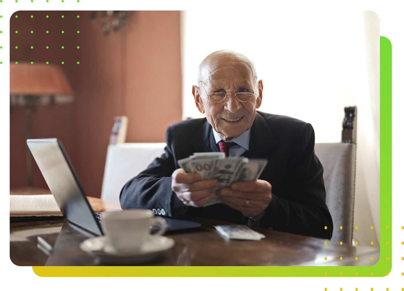 An old person wearing suit counting money in front of a laptop