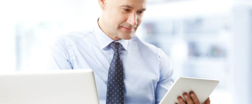 Portrait of efficiency financial advisor working at digital tablet while sitting at office.