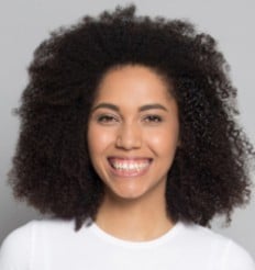 Headshot of a woman smiling with curly hair.