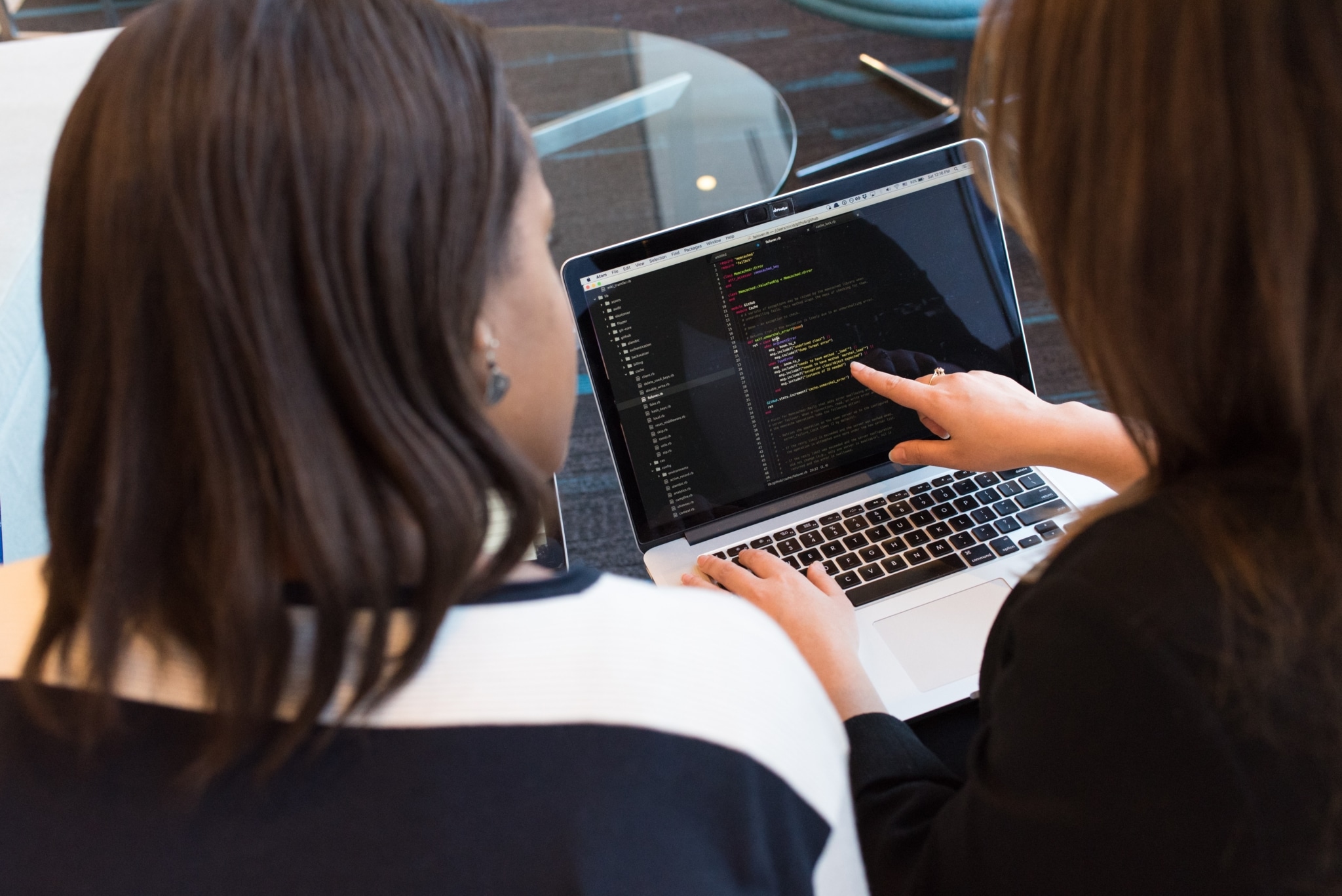 Two women staring at a laptop screen