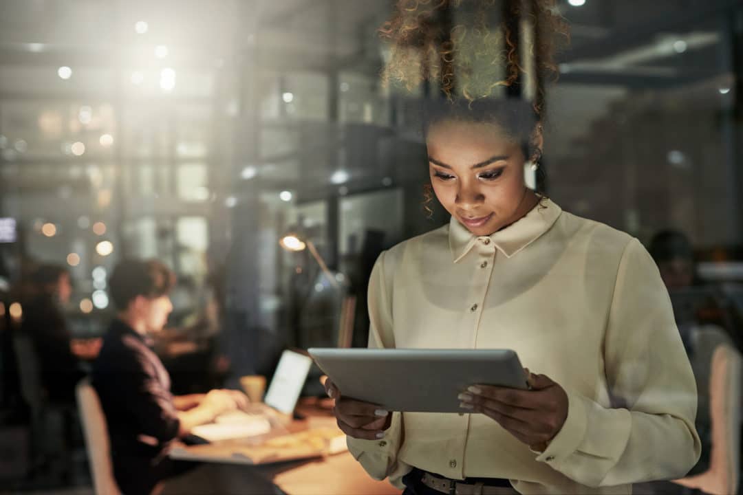 LeanLaw Well-dressed woman looking at tablet inside office