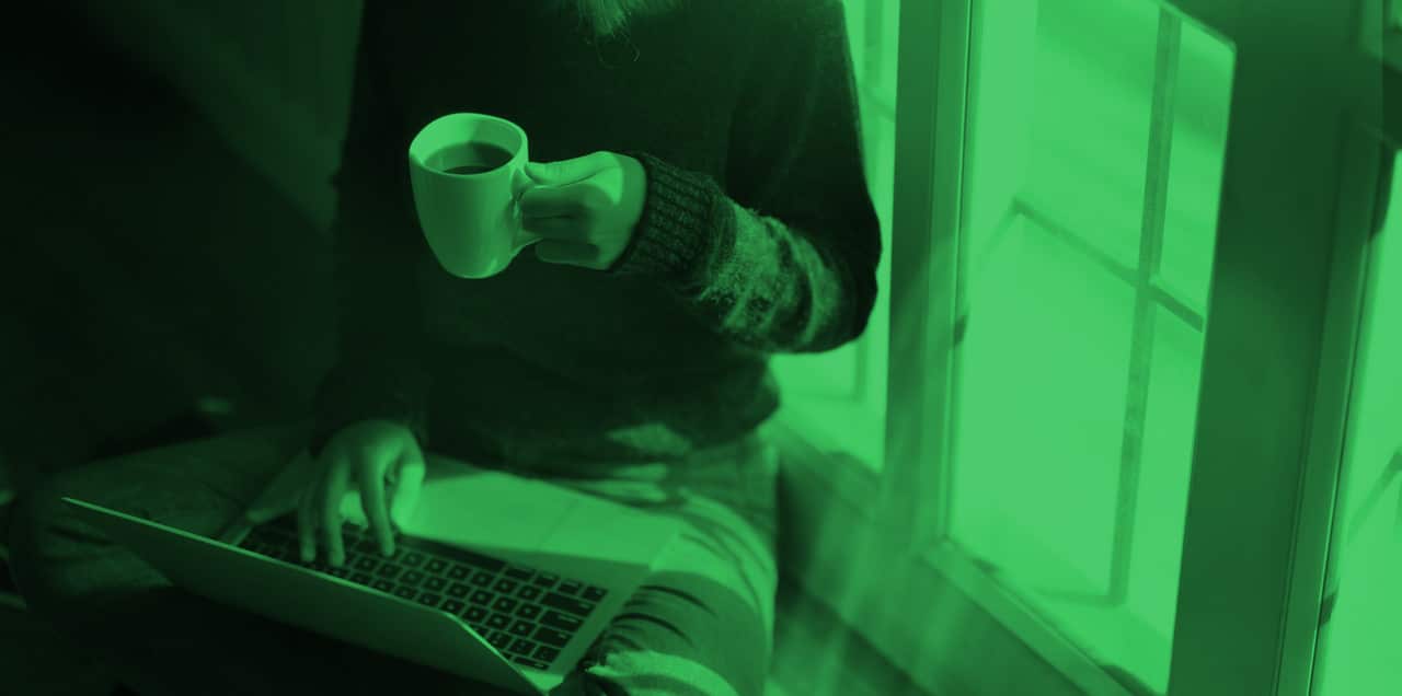 woman holding a cup of coffee and laptop